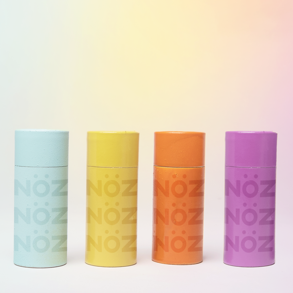 NOZ SPF30 Sunscreen, that is reef safe, and environmentally friendly. Comes in blue, yellow, orange, and purple. for a fun pop of color this summer.